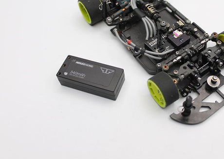 Reflex Racing RRE012 340mAh 7.6V LiHV hardcase RC car lipo battery lying on a surface with cables and tools nearby.