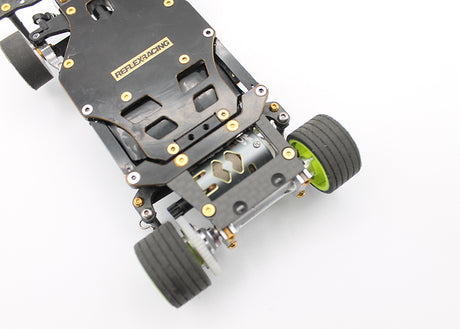 Reflex Racing RX28A-01 RC car rear brass and carbon fiber lower pod plate showing detailed metal and carbon fiber components.