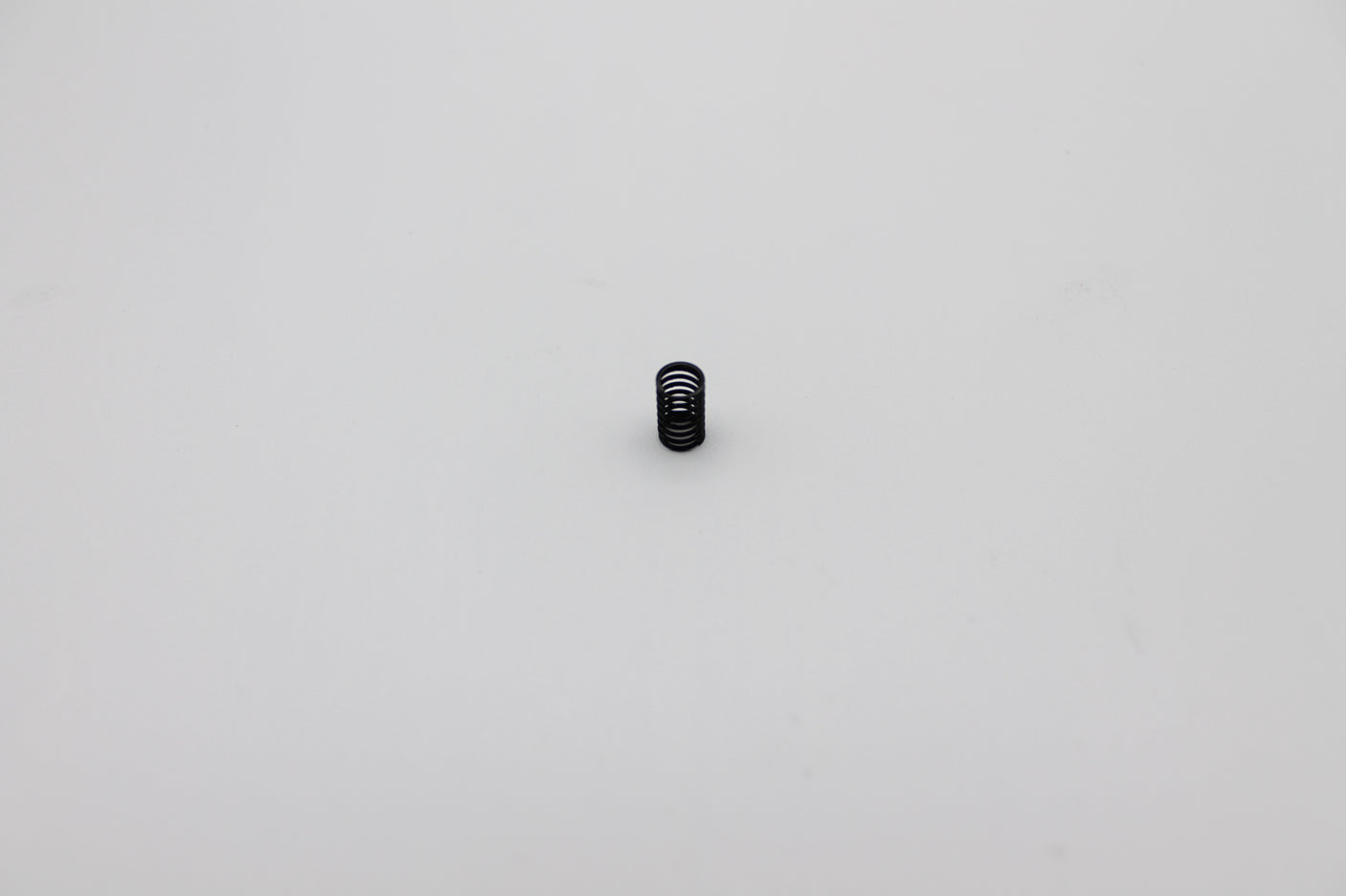 Reflex Racing RX28A-07 medium black center spring for RC cars, showing a close-up of the spring coil.