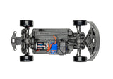 Traxxas 4-Tec Drift Ford Mustang remote control car on a racing track, showcasing its detailed black and white design.