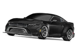 Black Traxxas 4-Tec Drift Ford Mustang radio-controlled car on a smooth surface.