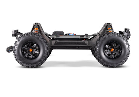 Traxxas X-Maxx 8S belted monster truck with large tires and rugged design on off-road terrain.