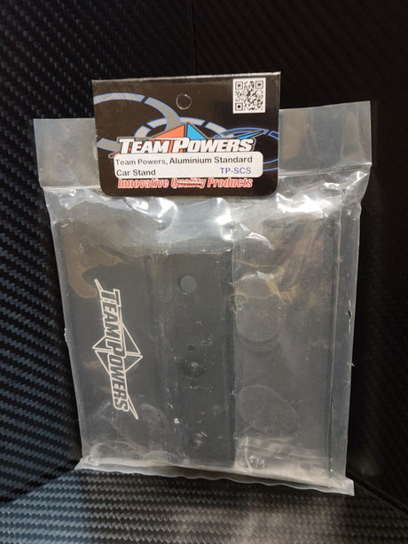Team Powers aluminum car stand supporting RC car tires, sturdy silver aluminum construction for remote control vehicle maintenance.