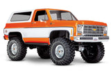 Orange Traxxas TRX-4 1979 Chevrolet Blazer radio-controlled scale model in a studio setting.