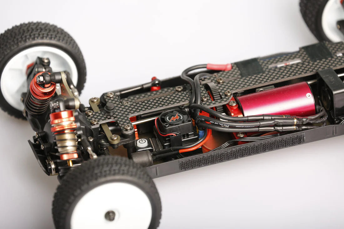 LC Racing LC12B1-HK 1/12 4WD competition buggy kit with motor and ESC, showing the assembled radio-controlled RC car on a track.