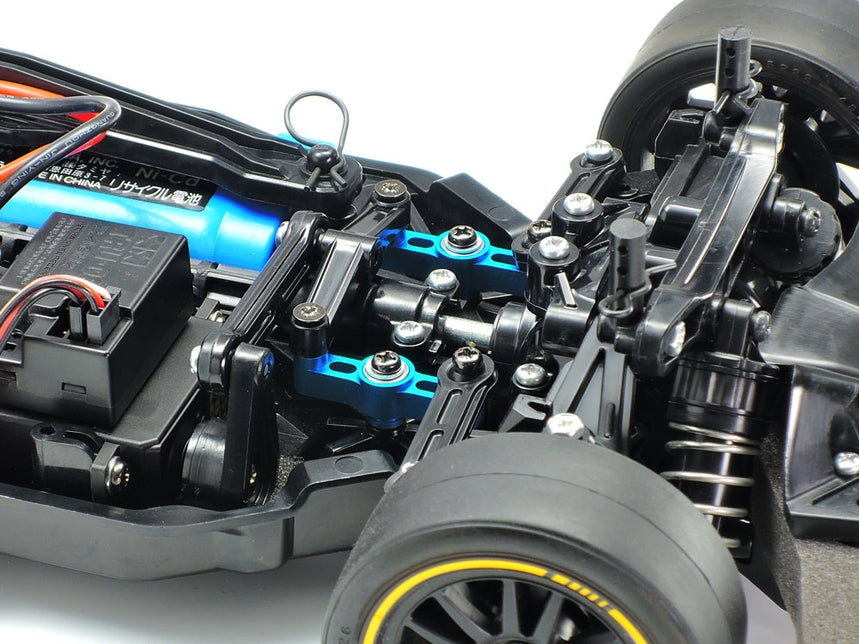 Tamiya TT-02 aluminum racing steering set installed on a remote control car with metallic components and precise steering linkages.