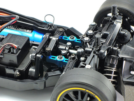 Tamiya TT-02 aluminum racing steering set installed on a remote control car with metallic components and precise steering linkages.