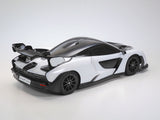 Tamiya TT-02 McLaren Senna RC car kit with detailed body shell and racing decals on a white background.