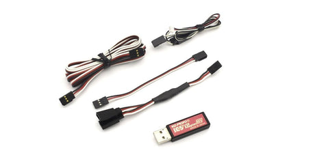 Kyosho I.C.S USB Adaptor HS 82083 connected to a compressor, showing a compact, black electronic adapter with USB port for RC tools.